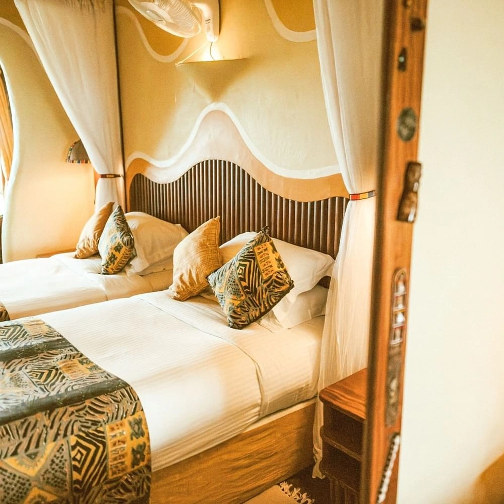 Beds between mosquito curtains in Standard Twin Room at Mara Serena Safari Lodge, featuring classic comfort in unique resorts