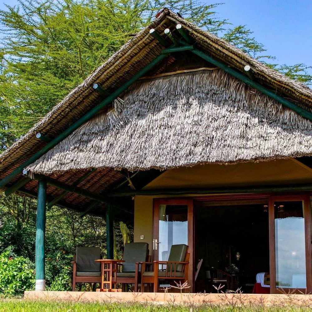 Thatch-roofed cabin in Morani Deluxe Tent at Sweetwaters Serena Camp, reflecting beauty of environmentally friendly resorts