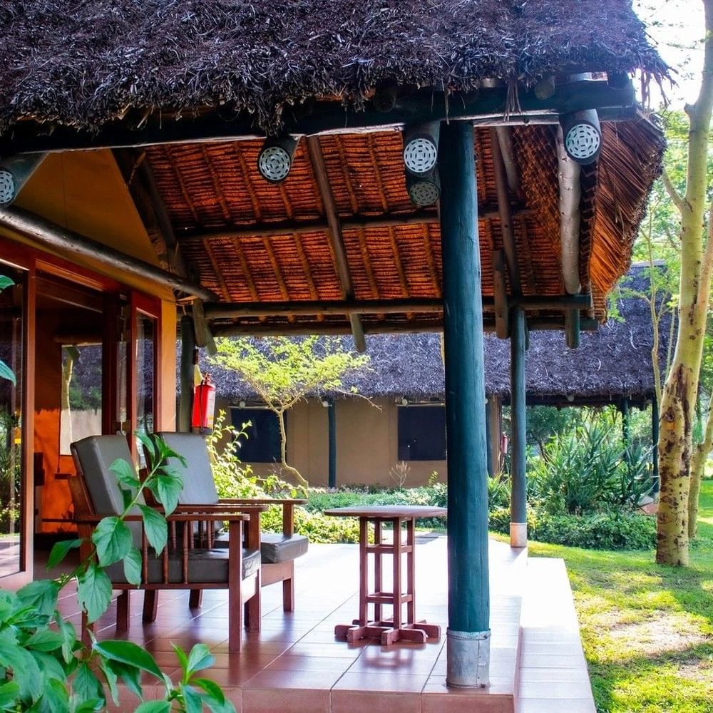 Thatched-roof with armchairs in Morani Deluxe Tent at Sweetwaters Serena Camp, nestled among environmentally friendly resorts